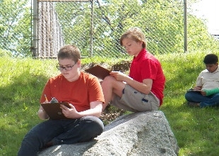 MEECS Students working on Assignments on a grass field (photo).